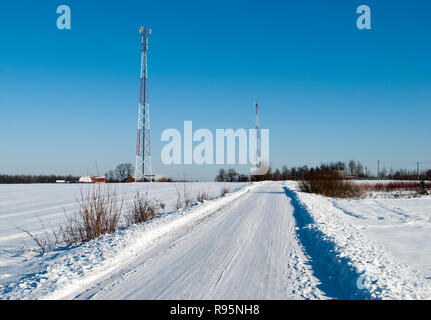 Der Winter Blick auf einer Landstraße mit Tk-Türme in einem Hintergrund (Litauen). Stockfoto