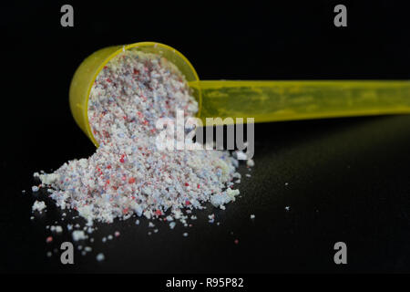 Pulver und Tabletten für die Spülmaschine auf dem Küchentisch. Reinigungsmittel für Haushaltsgeschirrspüler. Der dunkle Hintergrund. Stockfoto