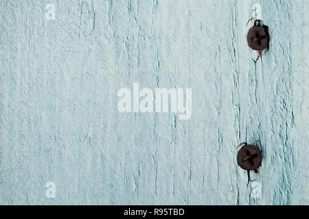 Die Textur von einem Board mit zwei rostige Nägel ist hell-türkis Farbe lackiert Stockfoto
