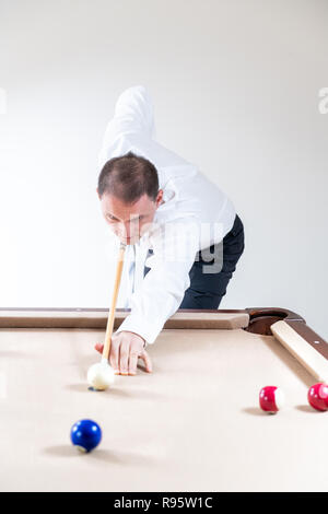 Junger Mann, Kaufmann in Riegel, weißes Hemd, Hose, Cue, Billardtisch, spielen Billard spielen, Billard, Billard, markanten weißen Ball, viele c Stockfoto