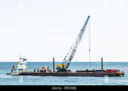 Piegon Key, USA - Mai 1, 2018: Bau mobiler Kran Bagger auf Schiff, Boot, Schiff, das im Ozean, Meer, Wasser, Reparaturen, Insel Gebäude afte Stockfoto