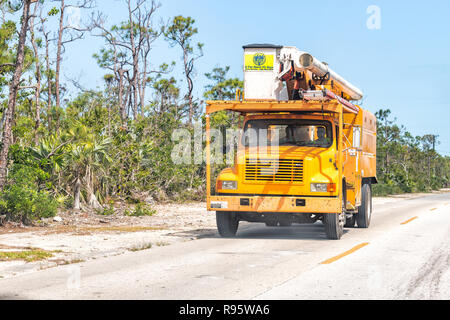 Big Pine Key, USA - Mai 1, 2018: ein Schnitt über FL Keys baum Professional Service-Lkw mit Schaufel, Arbeiter auf der Straße in Florida fahren, Bäume, Stockfoto