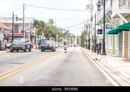 Key West, USA - Mai 1, 2018: Truman Avenue in Florida keys Stadt, städtische Blick auf Straße, Straße, Autos mit afrikanischen amerikanischen Mann überfahrt, jaywalking Stockfoto