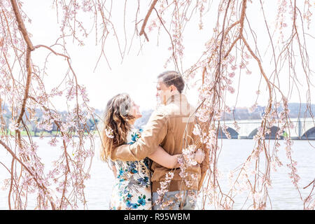 Paar, Frau, Mann unter Cherry Blossom stehend, sakura Blumen, Zweige, Baum, Potomac River, Washington, DC, sonnig, umarmt, umarmt, Arme aroun Stockfoto