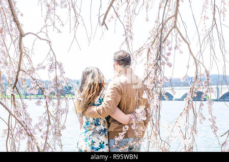 Paar, Frau, Mann unter Cherry Blossom stehend, sakura Blumen, Zweige, Baum, Potomac River, Washington, DC, sonnig, umarmt, umarmt, Arme aroun Stockfoto