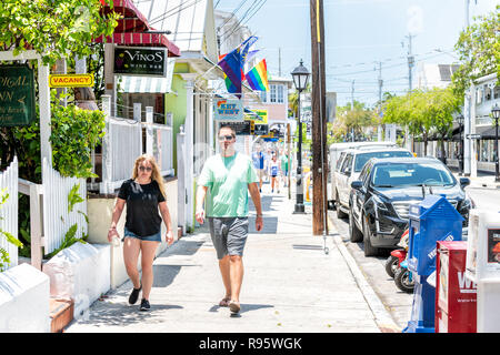 Key West, USA - Mai 1, 2018: Menschen, Paar auf Duval Street mit Tropical Inn, Weinstube, Restaurant, Cafe auf dem Bürgersteig, parkende Autos in Florida Stockfoto