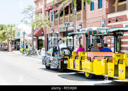 Key West, USA - Mai 1, 2018: Leute, Touristen, gelb schwarz Conch train geführte Tour Bus, Trolleybus mit Guide Treiber in Florida keys Stadt Insel o Stockfoto
