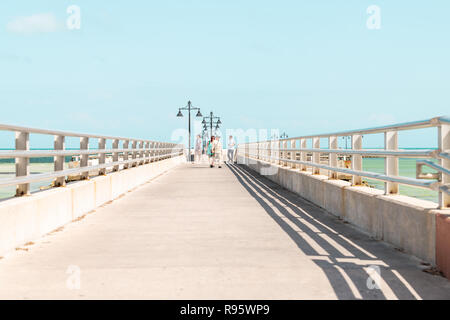 Key West, USA - Mai 1, 2018: Leute, Touristen zu Fuß am Steg, Pier in Florida am Ozean, Meer in der Nähe von Strand, Küste, Küste, flache grüne Wasser, Stadt Stockfoto