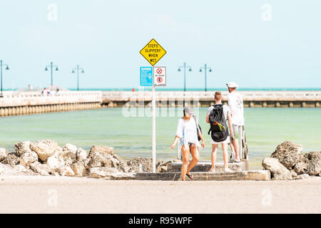 Key West, USA - Mai 1, 2018: Junge Menschen durch die Jetty, Higgs Pier in Florida, Meer, Meer, Strand, Küste, Küste, flache grüne Wasser, Vorsicht, Warnung si Stockfoto