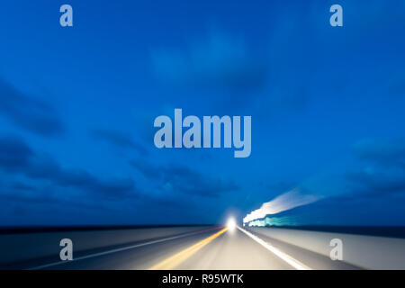 Abstrakte, begriffliche, Konzept lange Belichtung der Bewegung, einer Fahrt mit dem Auto von der Straße, Overseas Highway in Florida Keys, Scheinwerfer, Licht, lichter Streifen, b Stockfoto
