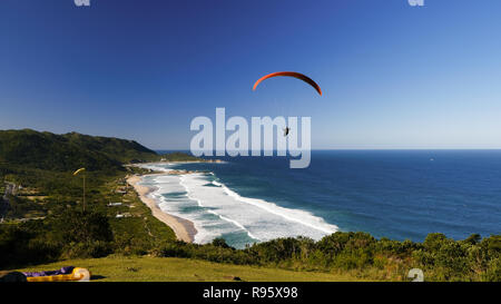 Paraglinding vom Hügel von Mole Strand über das Meer und die Berge. Florianópolis, Santa Catarina, Südamerika, Brasilien. Stockfoto