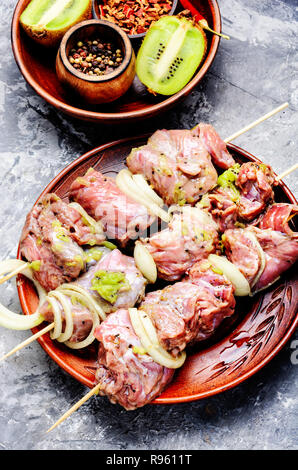 Rohes Rindfleisch Kebab in Kiwi. BBQ Marinade Fleisch auf Holzspieße Stockfoto