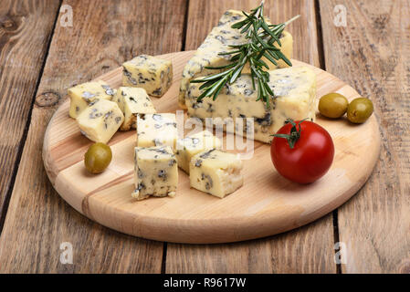 Blauen schimmel Käse, Rosmarin, Oliven und frischen Tomaten auf einem rustikalen Holztisch Stockfoto