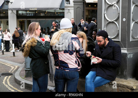 Junge Menschen Essen steht auf Stoney Straße Braten Restaurant Floral Hall in Borough Market, South London England UK KATHY DEWITT Stockfoto