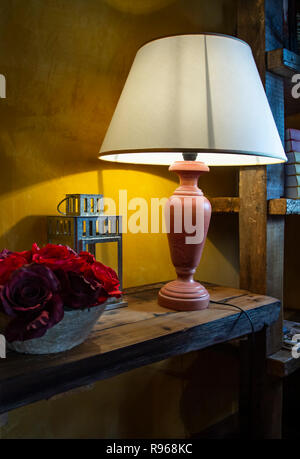 Schöne Nachttischlampe. Rote und purpurne künstliche Blumen. Auf einer Nachttischlampe, Dies ist eine schöne Nacht geschossen von einem leuchten Lampe. Stockfoto