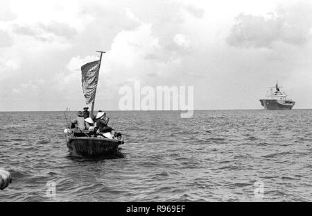 Ein 35-Fuß-Boot nähert sich dem Amphibischen Kommando Schiff USS BLUE RIDGE (LCC 19). Die Blue Ridge gerettet 35 refugeees 350 Meilen nordöstlich von Cam Ranh Bay, Vietnam, nach hatten Sie verbringen 8 Tage auf See im Boot. Stockfoto