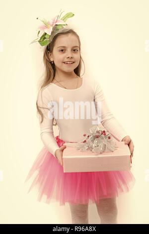 Vorhanden oder Geschenk geben. Mädchen ballerina Lächeln mit Box im rosa Tutu Rock. Urlaub, Geburtstag, Jubiläum zu feiern. Boxing Day Konzept. Kind mit Blume im langen blonden Haare isoliert auf Weiss. Stockfoto