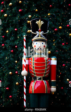 Stadtzentrum festliche Display mit Modell Spielzeug Soldat auf Sentry in vintage Red Coat einheitliche und Weihnachtsbaum mit Leuchten hinter Stockfoto