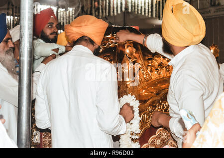 Amritsar, Indien - 16. MAI 2016: Unbekannter sikh Leute dekorieren Idol mit Ornamenten und Blume für endgültige bilden, bevor Puja. Golden Temple ist der Stockfoto