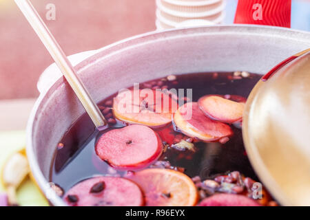 Glühwein im Bügeleisen Topf im city street fair vorbereitet. Traditionelle Weihnachten und neues Jahr Alkohol trinken - Glühwein. Mit Getränken in der Stadt Stall im Winter Stockfoto