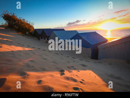 Der berühmte Strand Hütten in Abersoch, genießen den herrlichen Sonnenaufgang über der Westküste von Wales. Stockfoto