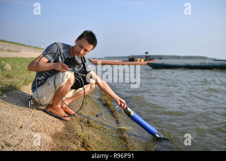 (181220) - CHANGSHA, Dez. 20, 2018 (Xinhua) - Li Xu, wissenschaftlicher Mitarbeiter, prüft die Wasserqualität im See Dongting, Zentrale China Provinz Hunan, Nov. 24, 2018. Sammeln von Boden im Frühjahr, Prüfung See Wasser im Sommer, Untersuchung von Pflanzen im Herbst und Beobachtung der Zugvögel im Winter umrissen fast zehn Jahre der saisonalen Zyklus tägliche Leben der namenlosen wissenschaftliche Forscher in der Dongting Lake. Sie haben hart gearbeitet, um Lösungen für den Schutz der Umwelt und der biologischen Vielfalt hier zu versorgen. Die Wissenschaftler von der Chinesischen Akademie der Wissenschaften (CAS) Wir Stockfoto