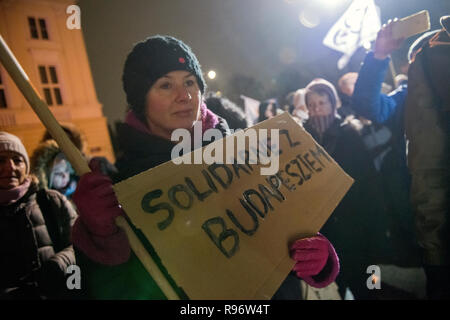 Eine Demonstrantin hält ein Plakat gesehen: Solidarität mit Budapest während eines Protestes außerhalb der Ungarischen Botschaft in Warschau in Solidarität mit den Demonstranten in Ungarn, die sich über das Wochenende gegen ein neues Arbeitsgesetz verabschiedet von der rechten konservative Regierung unter der Leitung von Viktor Orban demonstriert. Die ungarische Regierung hat eine Reihe von umstrittenen Gesetzen über die justizielle und Arbeit Themen bestanden, das neue Arbeitsrecht, bekannt als 'Slave' ermöglicht das Gesetz die Arbeitgeber zu bitten, ihre Arbeitnehmer auf bis zu 400 Stunden Mehrarbeit pro Jahr zu nehmen. Stockfoto