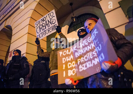 Die Demonstranten werden gesehen, Plakate während eines Protestes außerhalb der Ungarischen Botschaft in Warschau in Solidarität mit den Demonstranten in Ungarn, die sich über das Wochenende gegen ein neues Arbeitsgesetz verabschiedet von der rechten konservative Regierung unter der Leitung von Viktor Orban demonstriert. Die ungarische Regierung hat eine Reihe von umstrittenen Gesetzen über die justizielle und Arbeit Themen bestanden, das neue Arbeitsrecht, bekannt als 'Slave' ermöglicht das Gesetz die Arbeitgeber zu bitten, ihre Arbeitnehmer auf bis zu 400 Stunden Mehrarbeit pro Jahr zu nehmen. Stockfoto