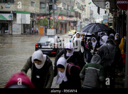 Dezember 20, 2018 - Gaza, Gaza, Palästina, palästinensische Studierende werden gesehen, um zu Fuß auf einer Straße durch eine starke Regenfälle im Flüchtlingslager Jabalya im nördlichen Gazastreifen überflutet. (Bild: © Mahmoud Issa/SOPA Bilder über ZUMA Draht) Stockfoto