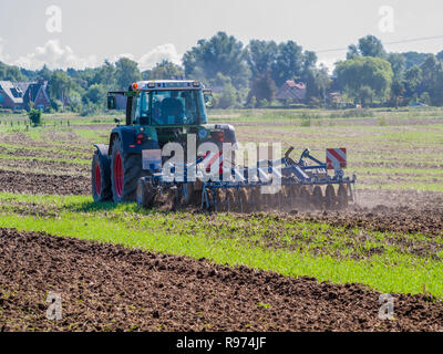 Landwirt pflegen seine Hektar mit seinem Traktor gezogene Egge in der Nähe von Barum, Elbmarsch, Deutschland. Stockfoto