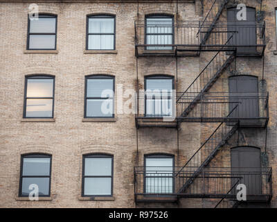 Notausgang Treppen und Leiter, aus Metall, auf einer typischen Nordamerikanischen alten Backsteingebäude aus dem alten Montreal, Quebec, Kanada. Diese Treppen, gemacht wurden. Stockfoto