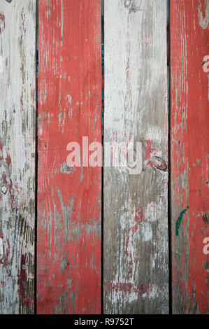 Rustikale Holz Hintergrund mit Peeling rot-weißen Streifen in einem full frame Close-up Zusammenfassung Hintergrund Stockfoto