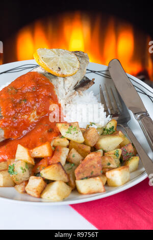 Ofen gebackene Makrelen auf einem Bett aus Reis mit sautierten Kartoffeln und eine Basilikum und Tomatensauce. Stockfoto