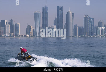 13.09.2010, Doha, Katar - ein Mann reitet einen Jet Ski im Persischen Golf mit der Skyline des central business district Al Dafna. Stockfoto