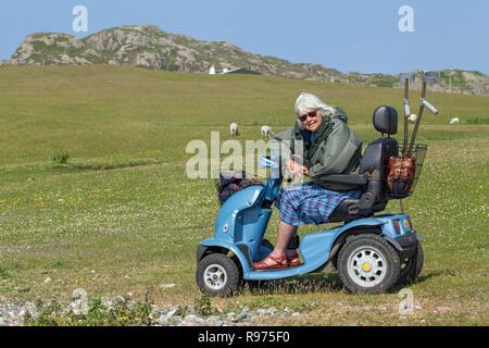 ​​Disabled. Körperlich beeinträchtigt. OAP. Eine ältere Frau, die ein Vierrädriges Elektrofahrzeug angenehm volle Unabhängigkeit und der Zugang zu den ländlichen Szene, die Landschaft und die Umwelt im Allgemeinen geben. Iona. Die Inneren Hebriden. Argyll und Bute, Schottland. ​ Stockfoto