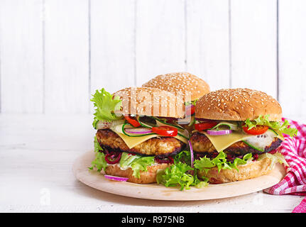 Leckeres vom Grill hausgemachte Hamburger mit Burger Huhn, Tomate, Käse, Gurken, Salat und Rote Beete. Sandwich. Mittagessen Stockfoto