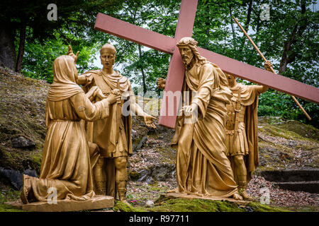 Lourdes (Frankreich). Station des Kreuzes "Les Espelugues" schlängelt sich durch eine steile Steigung und einem Wald. Im Jahr 1912 abgeschlossen und auf dem Hügel von Espelugues gelegen, ca. 115 golden Gusseisen Zeichen markieren Dieser 1.500 m lange Weg des Kreuzes. Die Stationen wurden von Wohltätern, Gruppen oder diözesen angeboten. 6. Station: Veronica Wipes das Antlitz Jesu Stockfoto