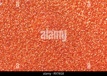 Helles orange funkelnden Hintergrund von kleinen Pailletten, Nahaufnahme. Brillant glänzende Kulisse aus Textil. Shimmer coral Papier Stockfoto