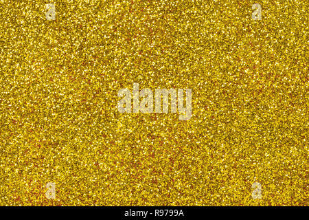 Golden funkelnden Hintergrund von kleinen Pailletten, Nahaufnahme. Brillant glänzende Kulisse aus Textil. Shimmer gelbes Papier Stockfoto