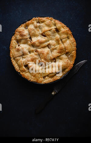 Apfelkuchen mit Gitter Dekoration auf dunklem Hintergrund Stockfoto