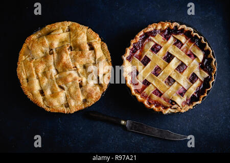 Apfelkuchen und Kuchen mit Beeren auf dunklem Hintergrund Stockfoto