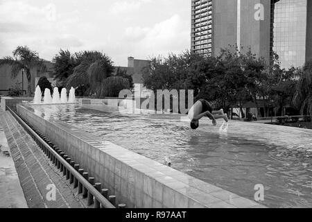 MONTERREY, NL/MEXIKO - Nov 2, 2003: ein Junge nimmt ein erfrischendes Bad an einem öffentlichen Brunnen vor dem Macroplaza, von der Hitze zu entkommen Stockfoto