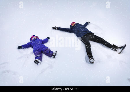 Mutter und Kind, das die Engel im Schnee Stockfoto