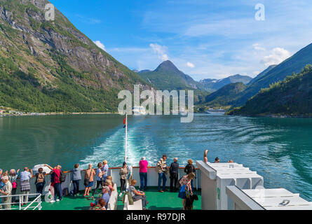 Touristen auf dem Deck der Geiranger nach Hellesylt Fähre Blick zurück in Richtung der Stadt Geiranger, Geirangerfjord, Norwegen Stockfoto