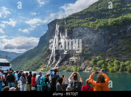 Touristen fotografieren von einem Wasserfall von der Plattform des Geiranger nach Hellesylt Fähre, Geirangerfjord, Norwegen Stockfoto