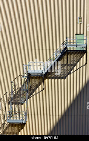 Abstraktes Muster aus Metall Notausgang Treppen und vertikal orientierten Wellblech verkleideten Gebäude Stockfoto