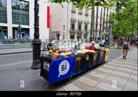 Ein Stall verkaufen T-Shirts und katalanischen Fahnen auf dem Bürgersteig entlang der La Rambla, Barcelona, Spanien Stockfoto