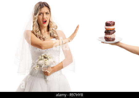 Wütende Braut ablehnen, einen Teller mit Donuts und Gestik, die nicht mit der Hand auf weißem Hintergrund Stockfoto