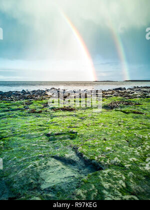 Regenbogen über der berühmten Fußabdrücke von Dinosauriern zu einem corran Strand von staffin auf die Isle of Skye - Schottland Stockfoto