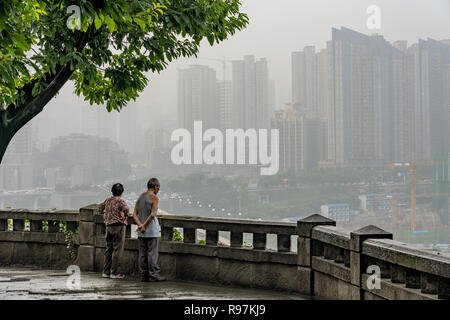 Nebelige Szene von Menschen auf einem Hügel über Chongqing Stadt suchen Stockfoto